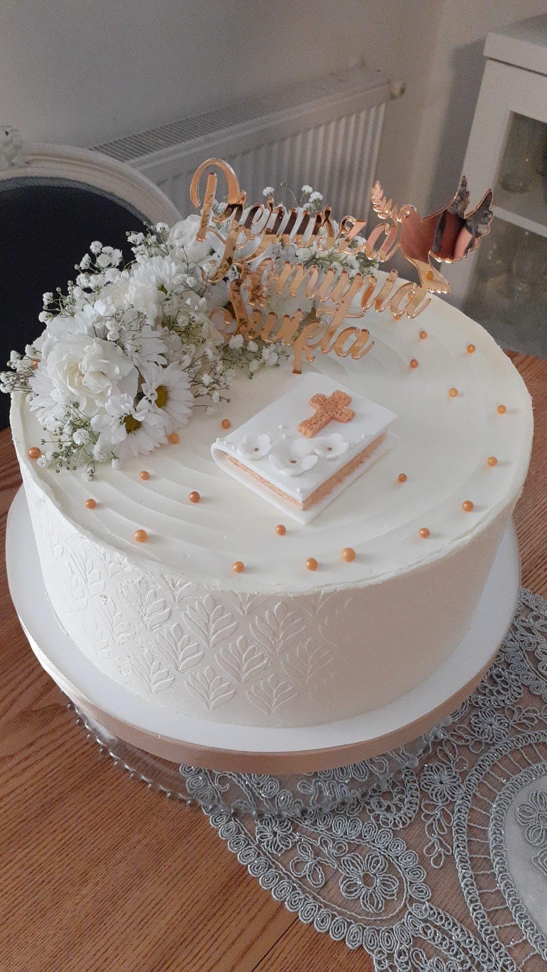 Tort na Komunię z białymi stokrotkami i złotym topperem